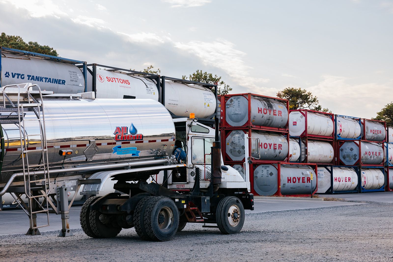 all-chem-tanker-truck-driving-along-iso-container-stacks