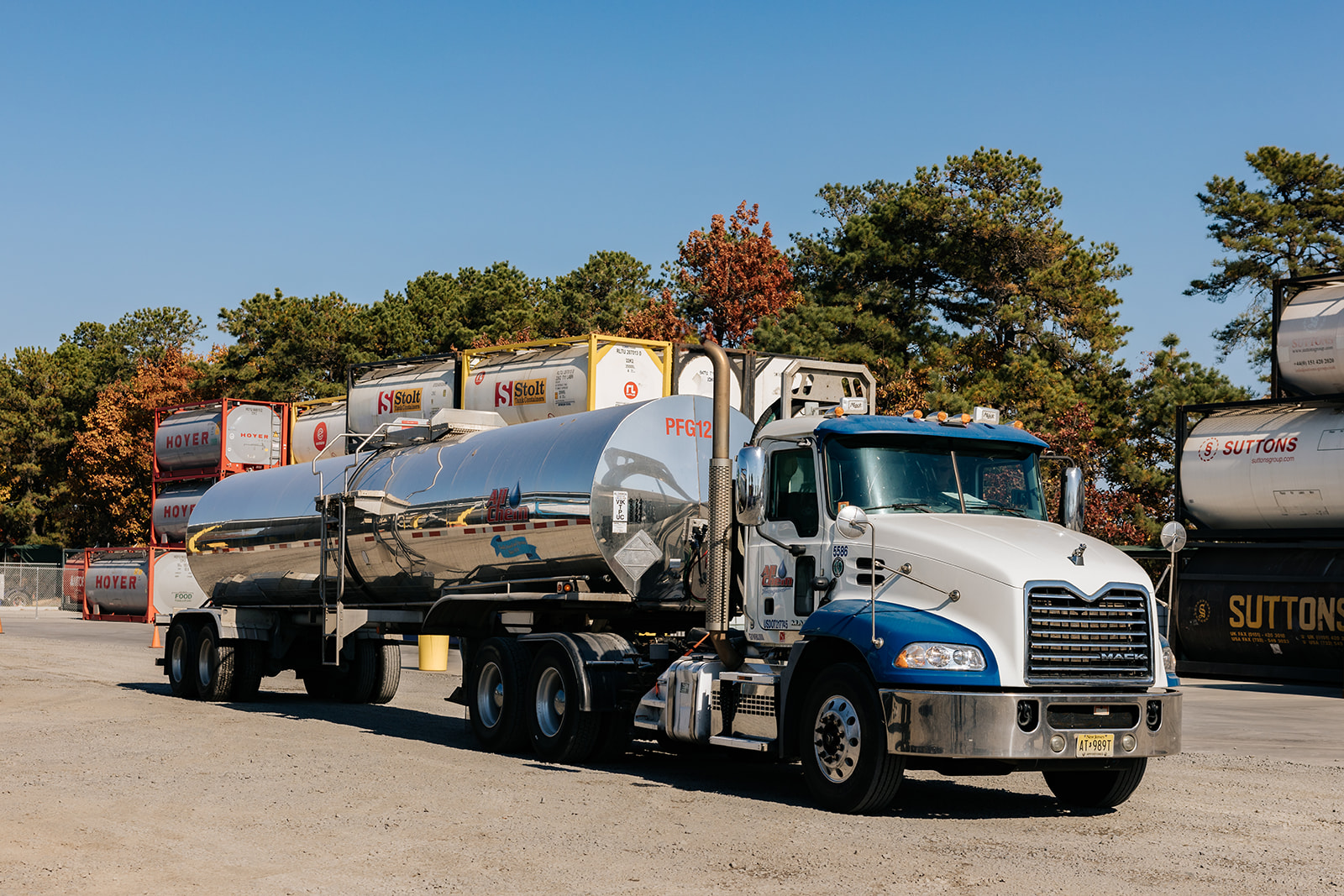 all-chem-tanker-truck-driving-along-iso-container-stacks